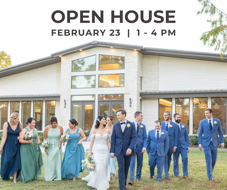 Wedding party walking in front of a white building with tall glass windows